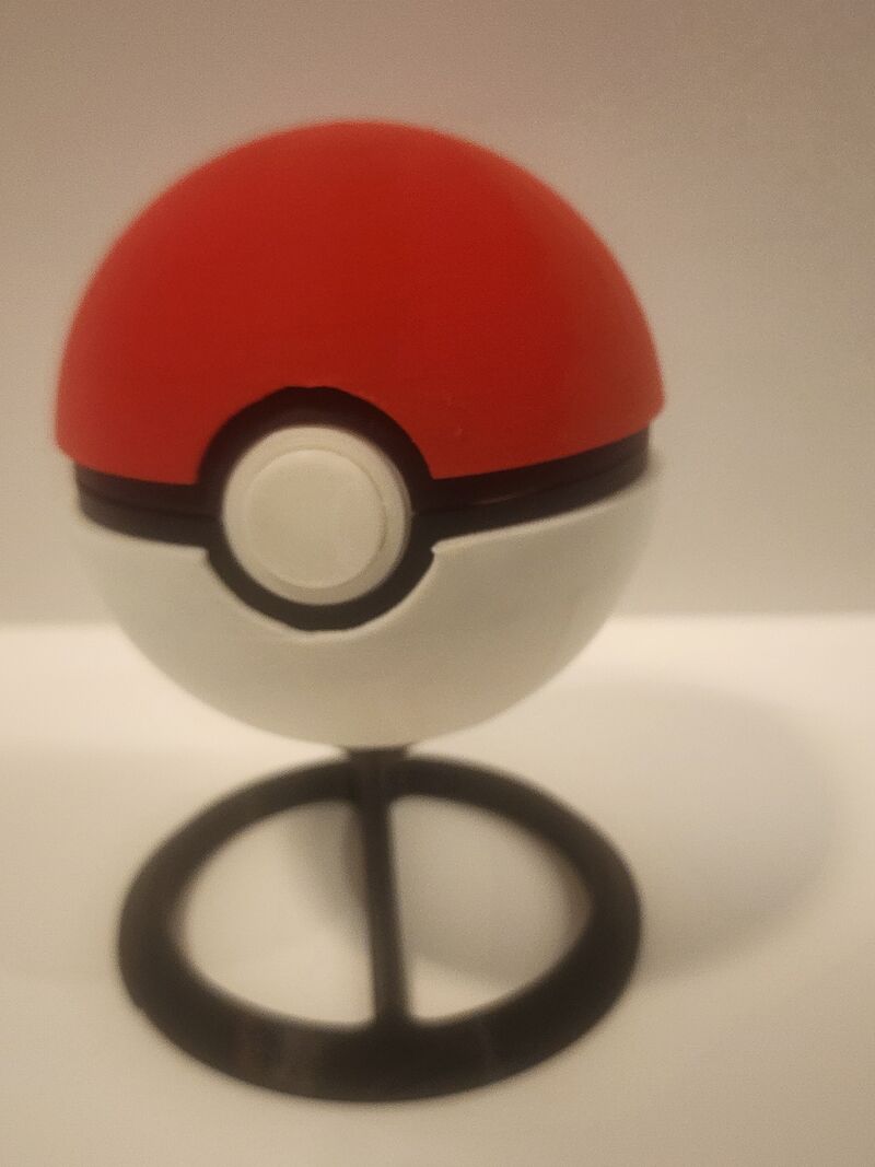 3D printed Pokéball that opens, with black display stand included. Fan-made collectible. Printed in red and white PLA with black stand. Great desk display or gift for any Pokémon fan. Surprise bonus may be included!
